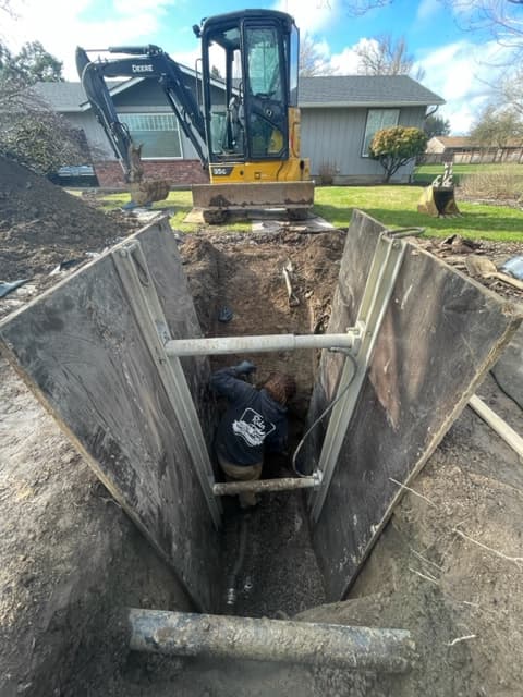 Excavation equipment and employee clearing dirt